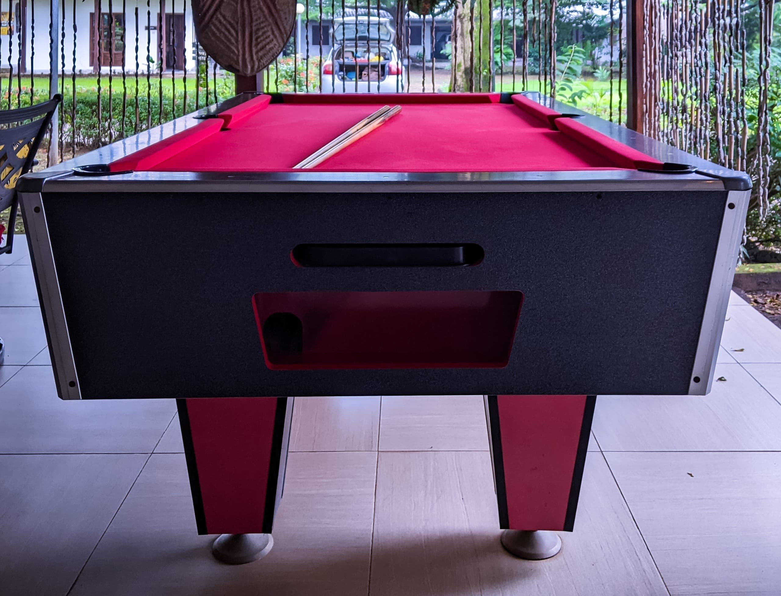 The lounge's pool table corner, beneath rattan lanterns