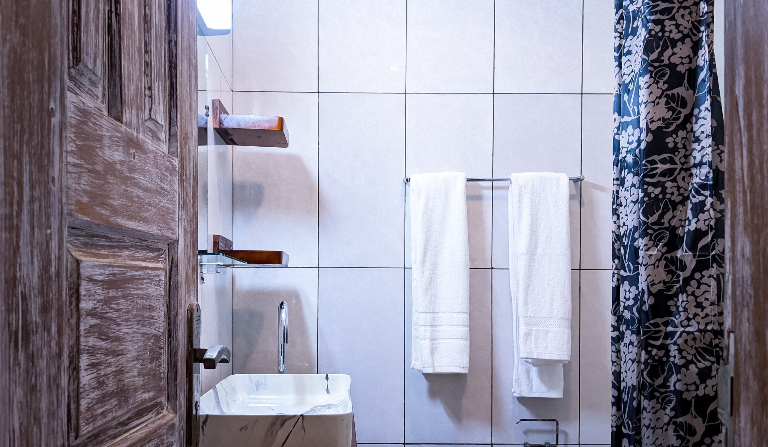 Bathroom sink, towels and the floral shower curtain
