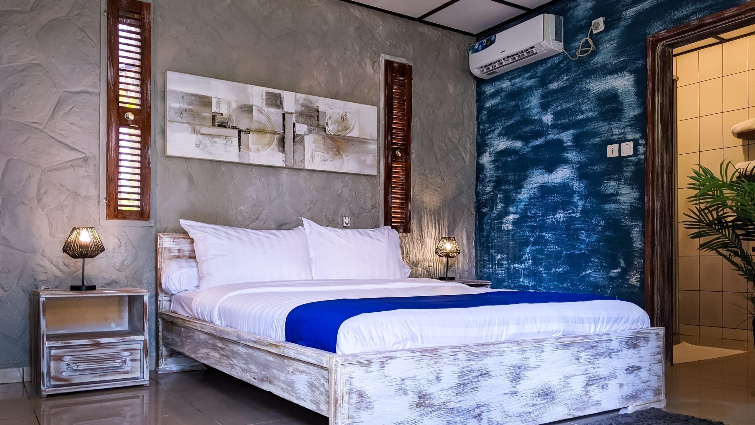 Wide view of the bed against a deep indigo wall