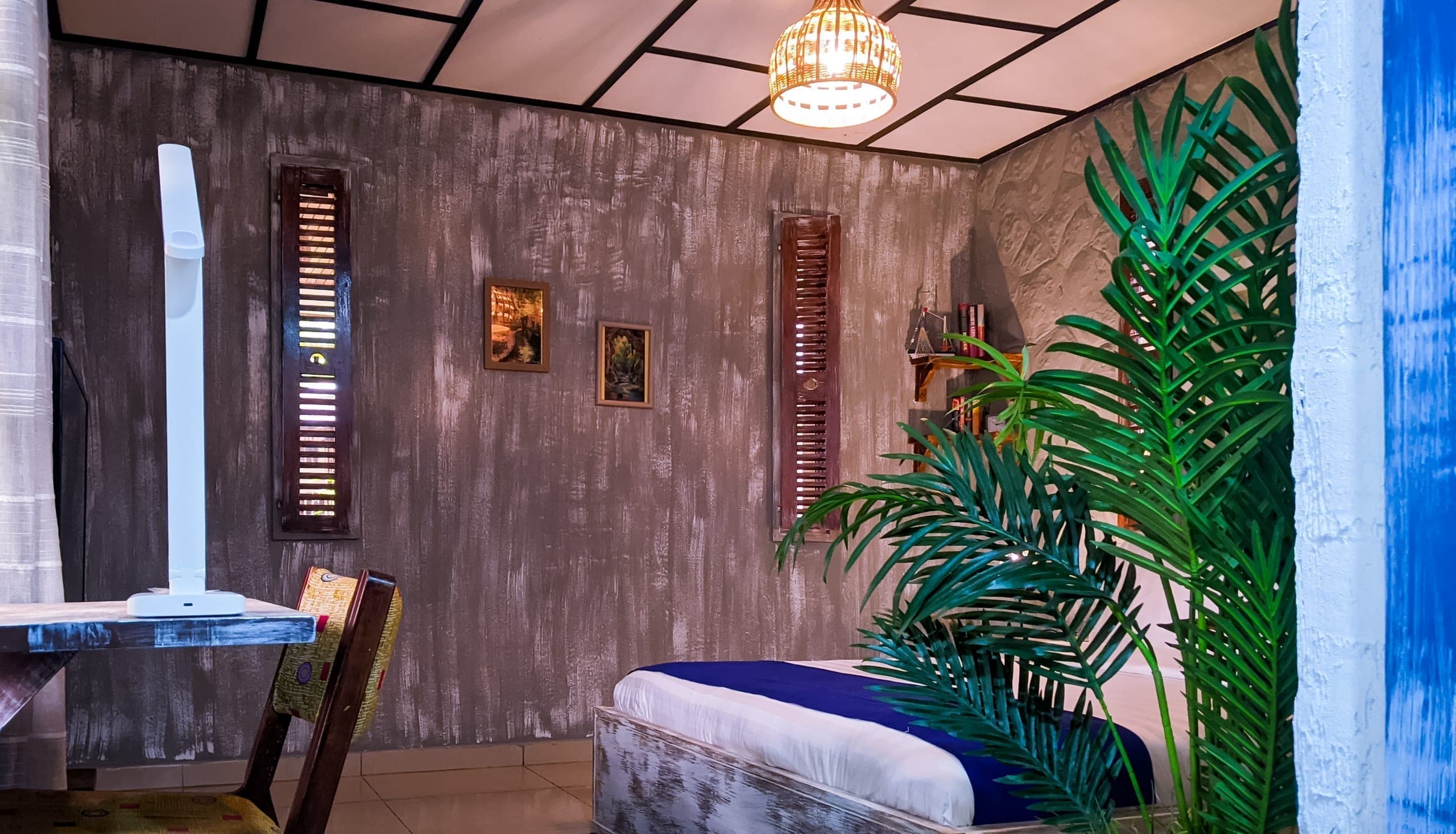 Sitting corner with desk, television, and bookshelf behind a potted palm