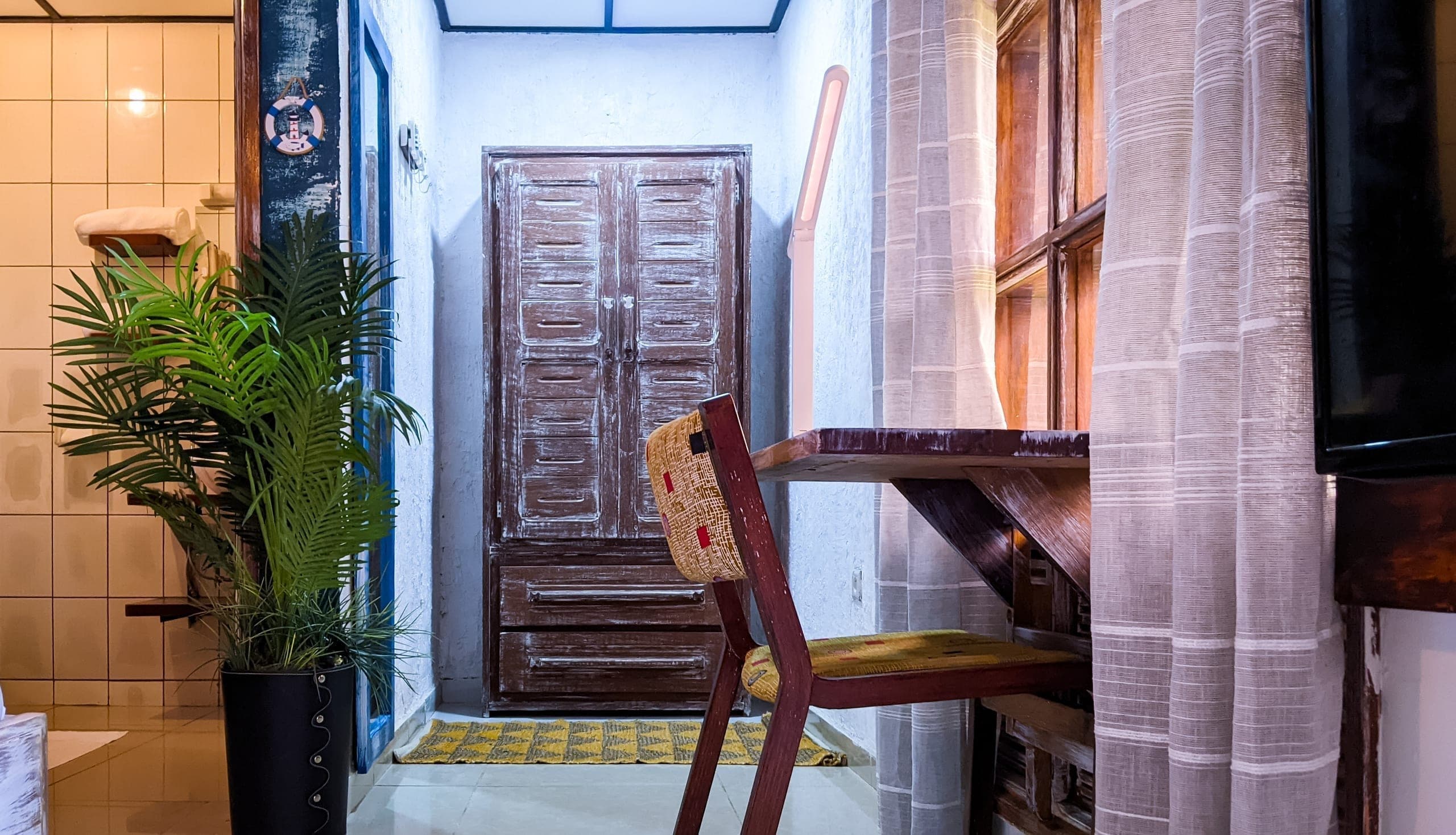Wardrobe and writing desk nook by the curtained window