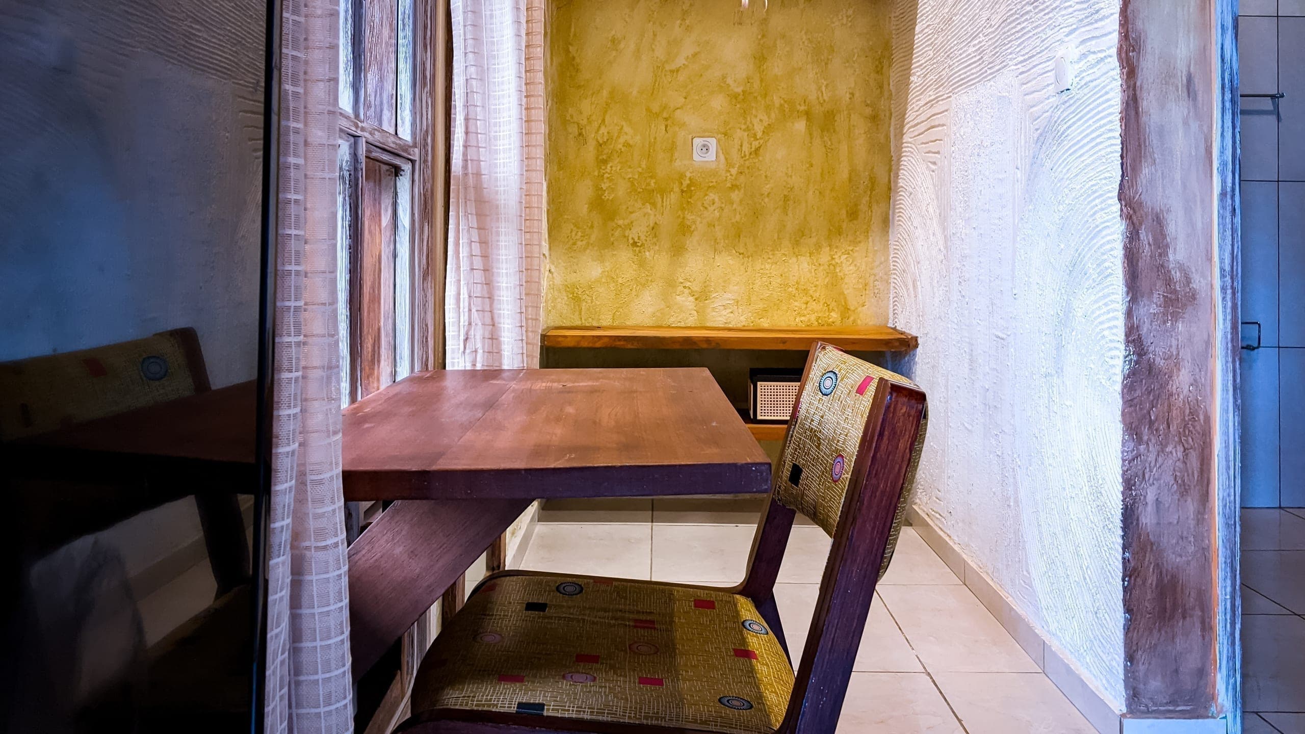 Room view toward the open bathroom door, desk nook in the foreground